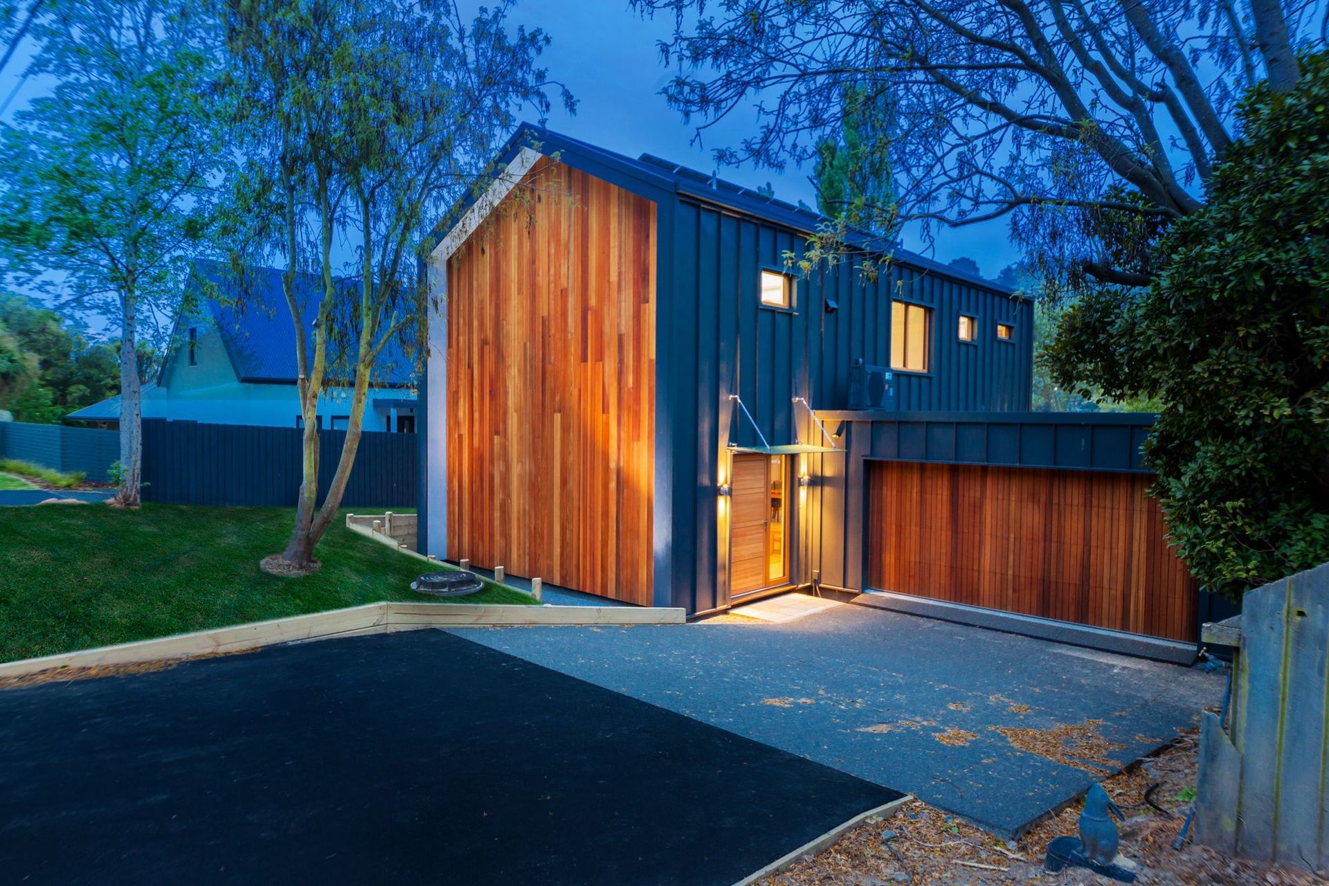 The entryway of the Pitkin-Douglas Passive House at night where solar panel-cladding can be seen on the north-facing roof.