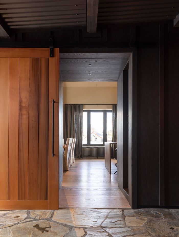 The exterior cladding and corrugated iron roof of the lean-to entrance that joins the two building forms. Clutha stone is on the floor.