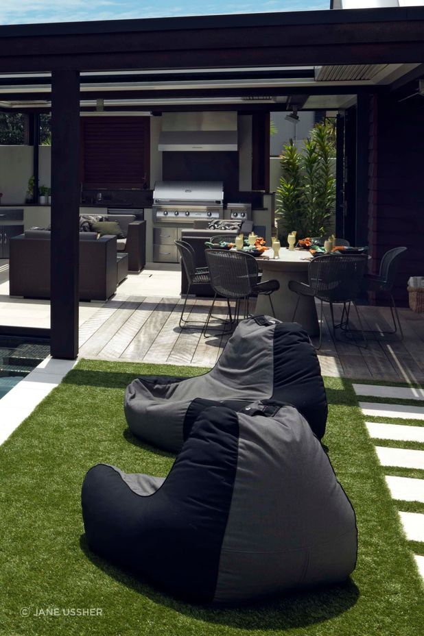 The outdoor kitchen and dining areas are adjacent to low-maintenance turf.