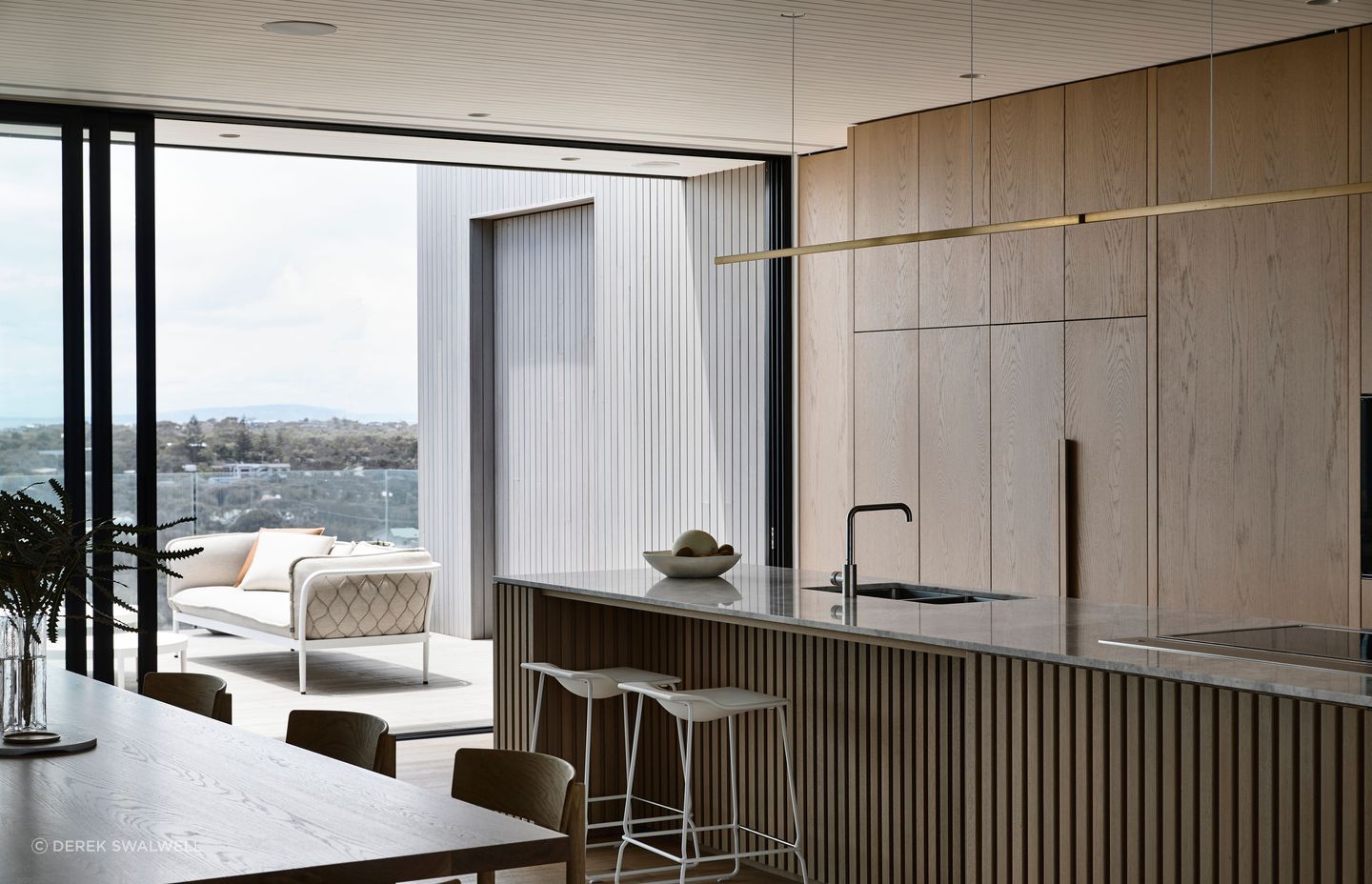 The seamless timber kitchen cabinetry warms the space.