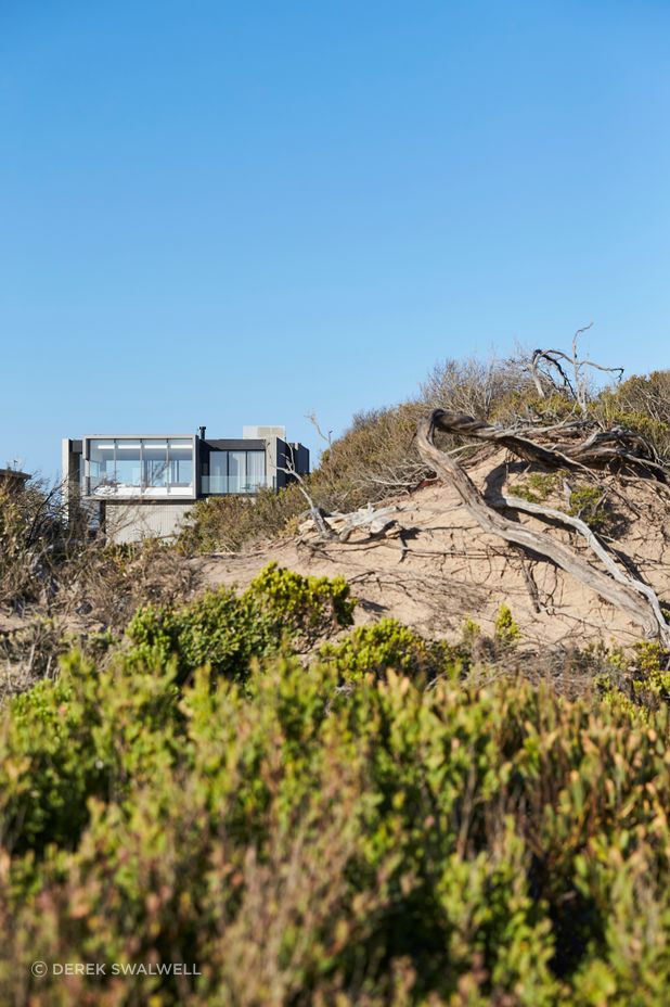The concrete form of the home integrates into the beach setting.