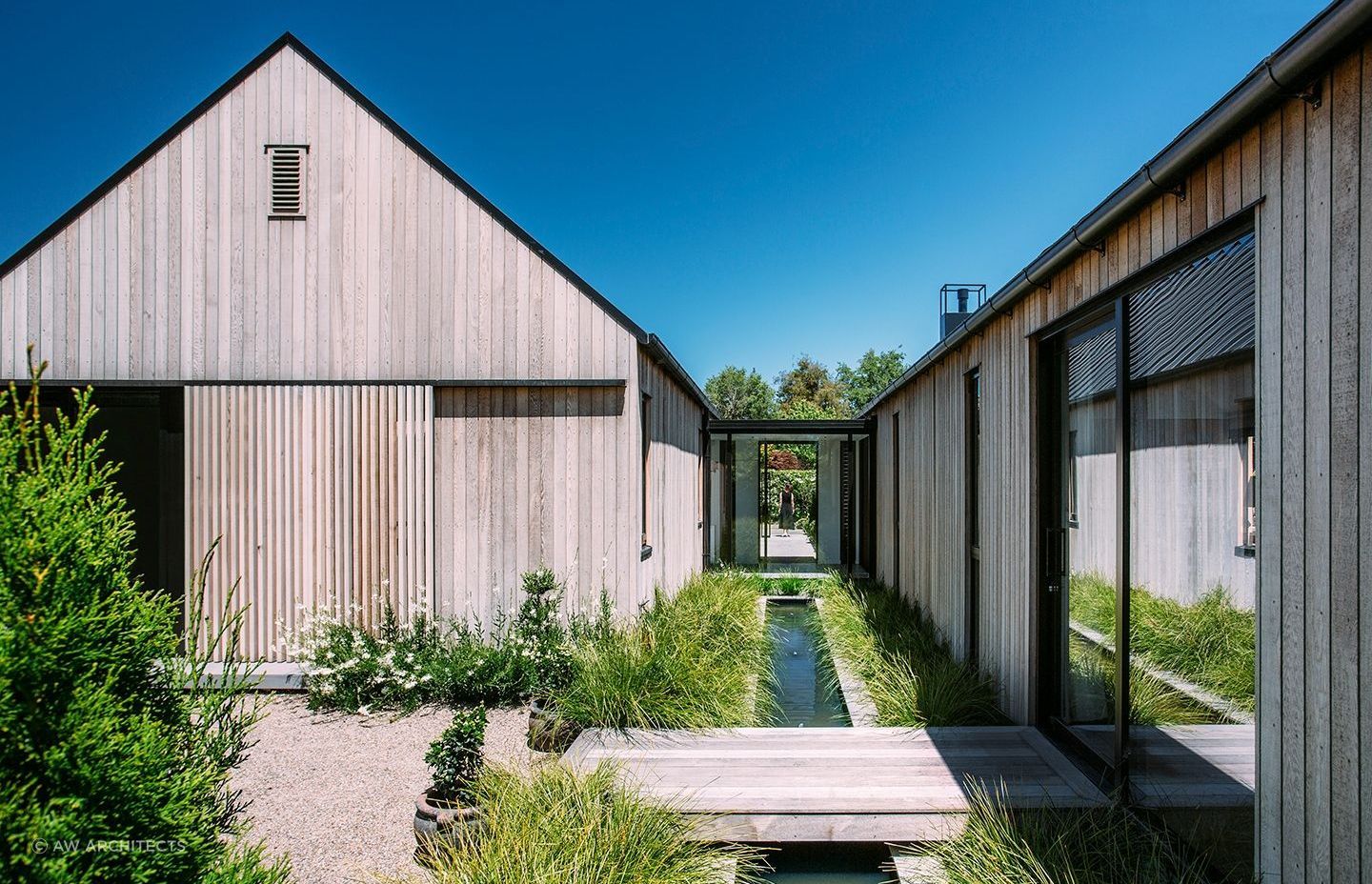 The rill between the two structures complements the home's riverside setting. | Photography: Lisa Gane