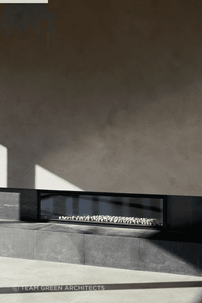 The entrance leads into the centre of the home, opening into an open-plan kitchen, living, and dining space with an oversized fireplace.