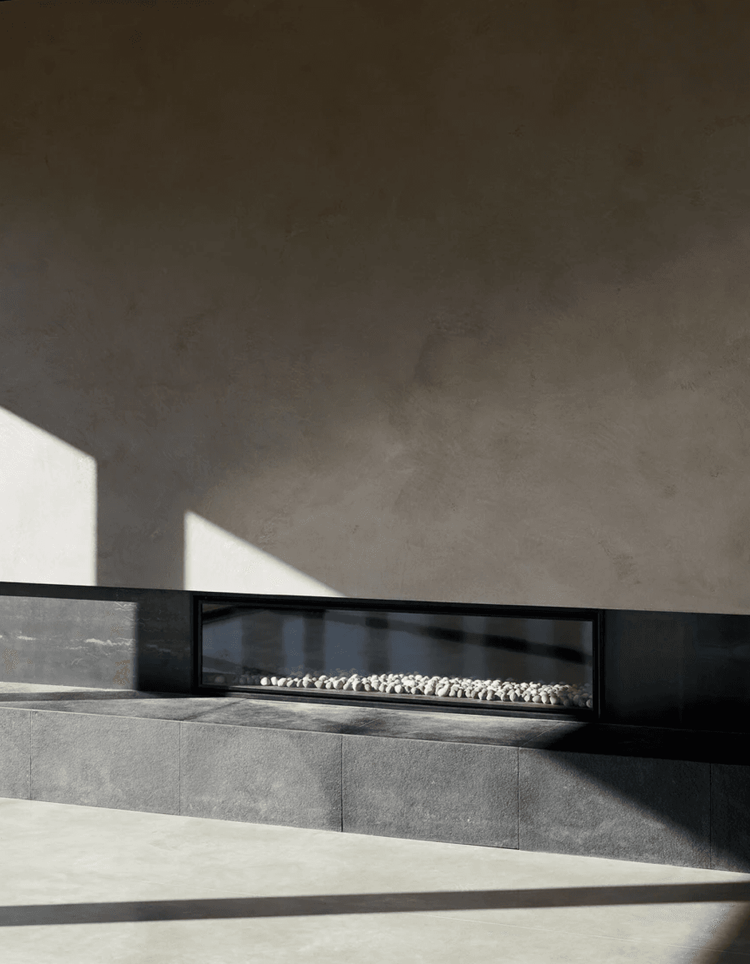 The entrance leads into the centre of the home, opening into an open-plan kitchen, living, and dining space with an oversized fireplace.