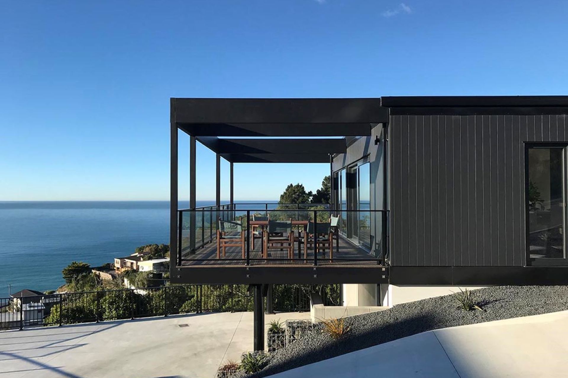 The home features cantilevered outdoor living space with movable shutters for privacy and shelter when needed.