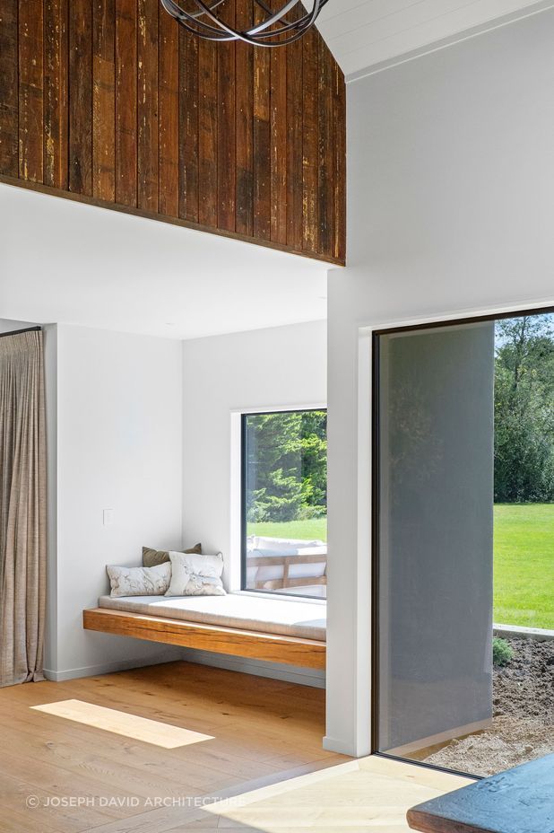 The window seat is a perfect space of refuge overlooking the green lawn.