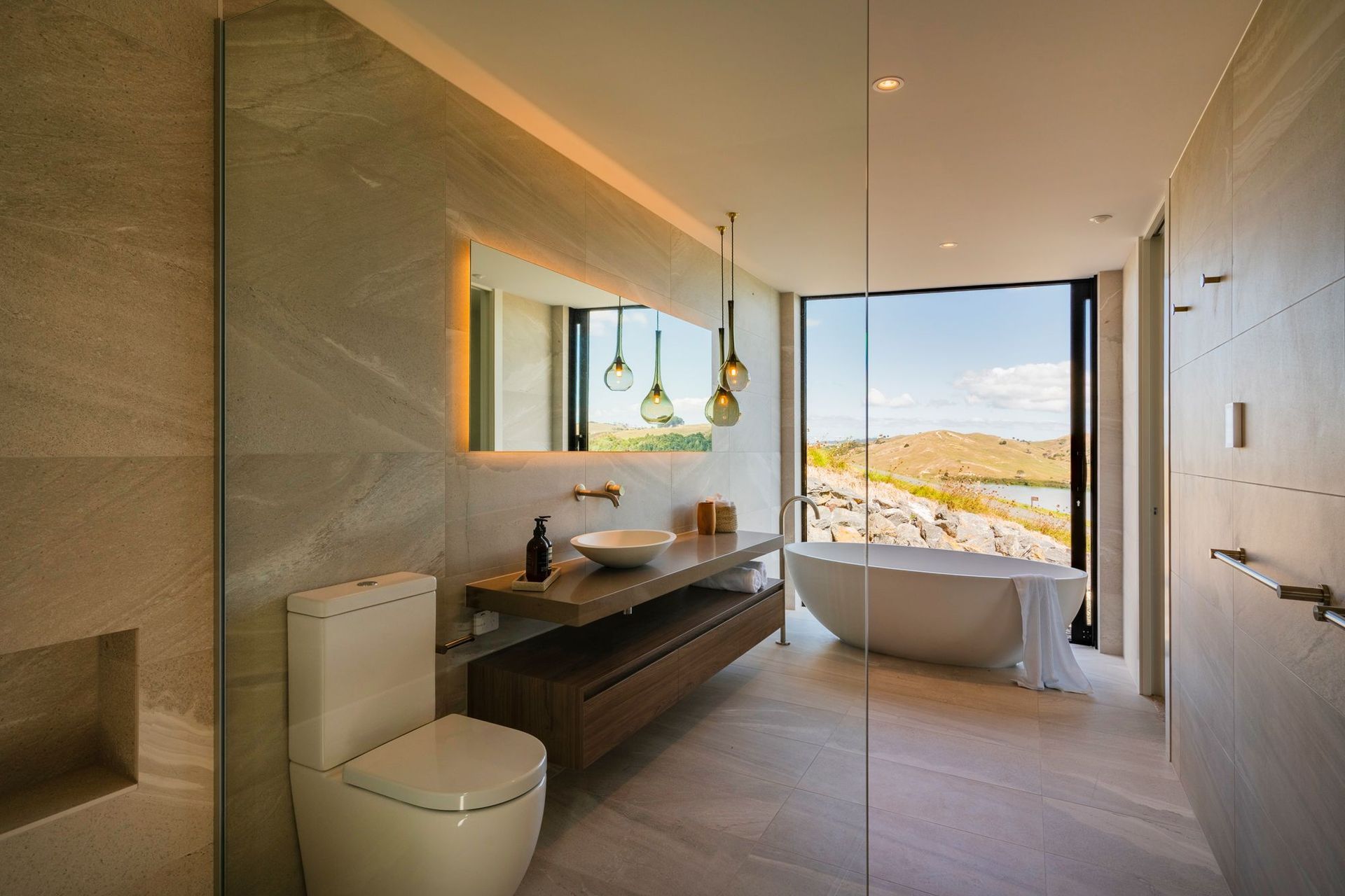 Every detail has been considered in the bathroom, with a bespoke vanity, large format tiles and a Waterware bathtub that overlooks the stunning view.