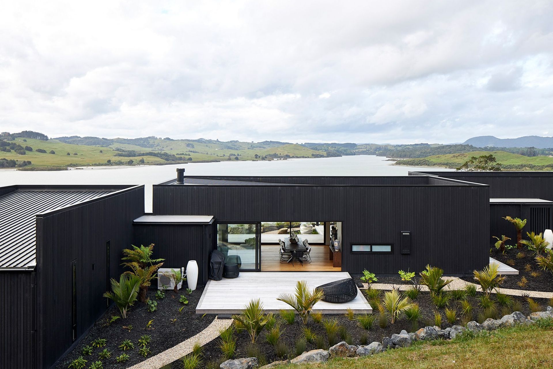 Cedar cladding coated in Pitch Black Resene CoolColour Wood Stain has been used for the exterior – a durable option that reflects a large proportion of heat.