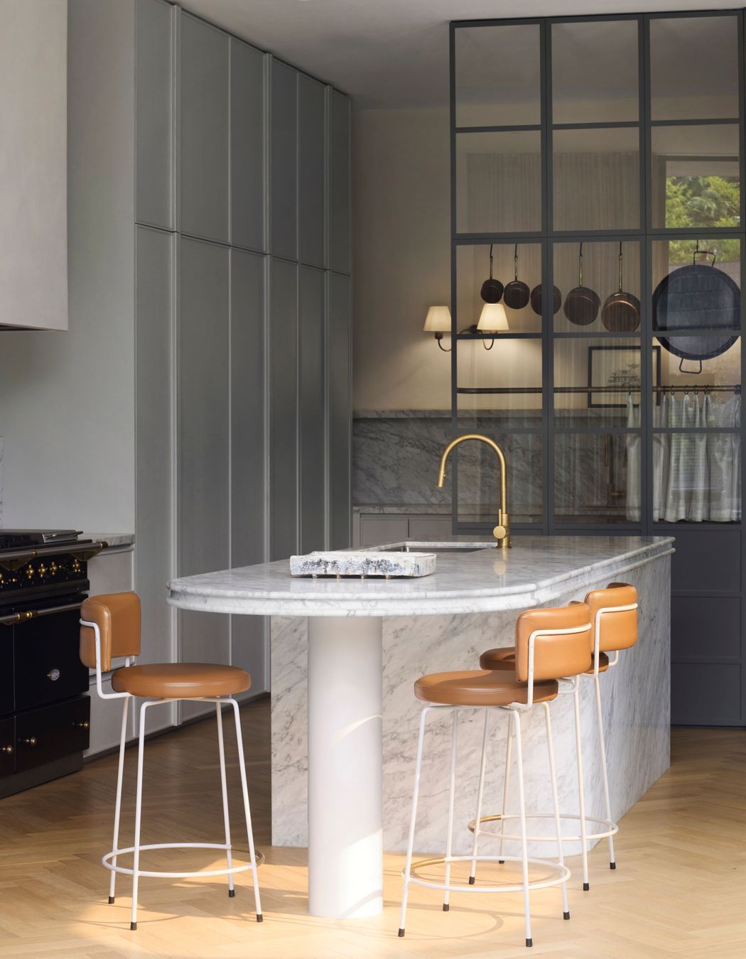 Curves are repeated in the shape of the kitchen island, lending a softness to the space.