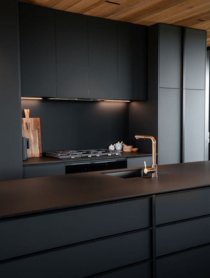 The kitchen's sleek, monotone scheme adds to the seamless aesthetic of the space.