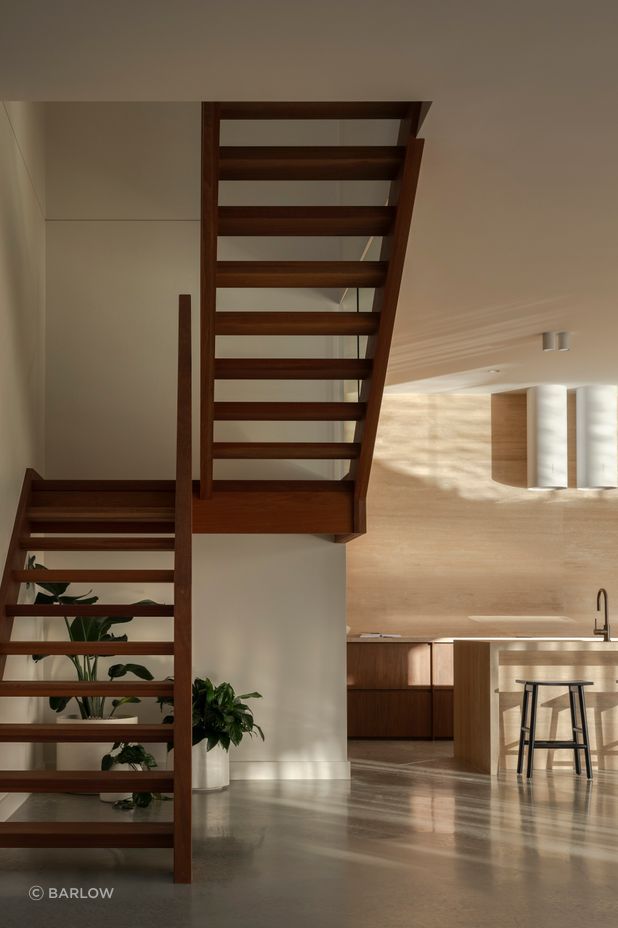 The entry opens to a double void, with the open-plan kitchen, living and dining beyond.