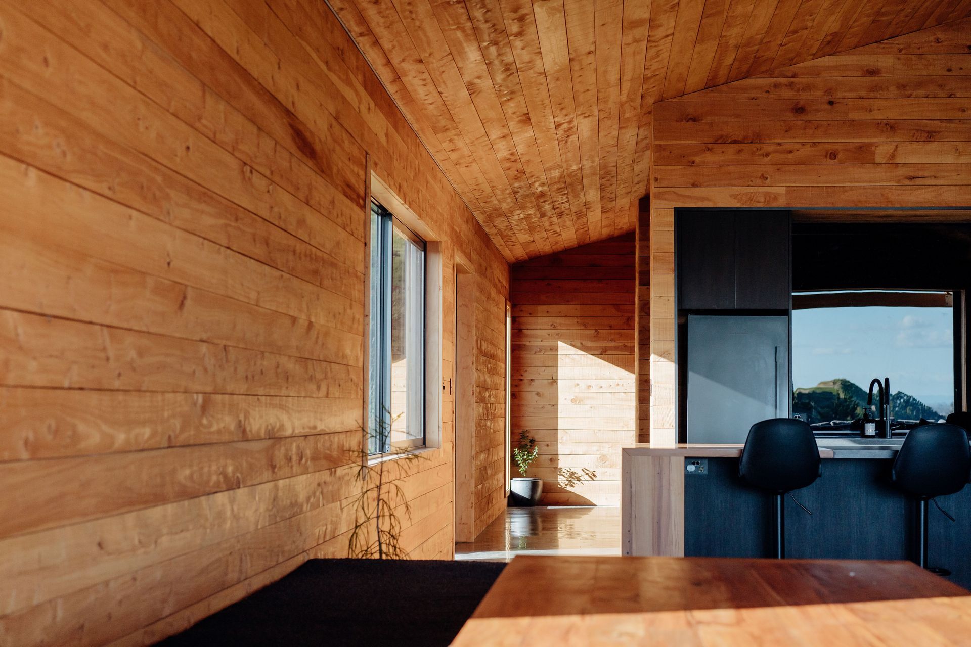 The interior macrocarpa brings a warmth to the living areas, and the island bench waterfall ends use recycled Totara from the farm woolshed.