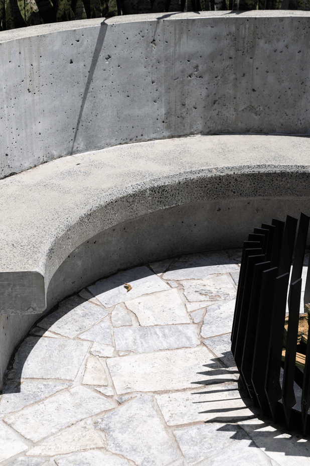 Curves, concrete and stone continue to the backyard where the family can gather around the fire pit.