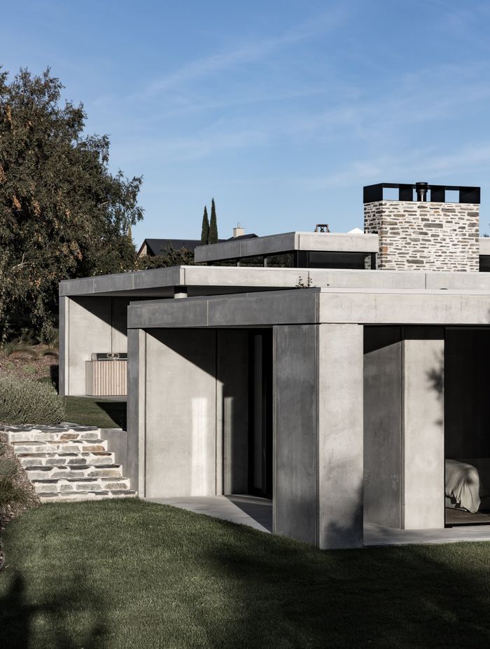 The exterior material palette is robust and protective, largely formed of concrete and stone.