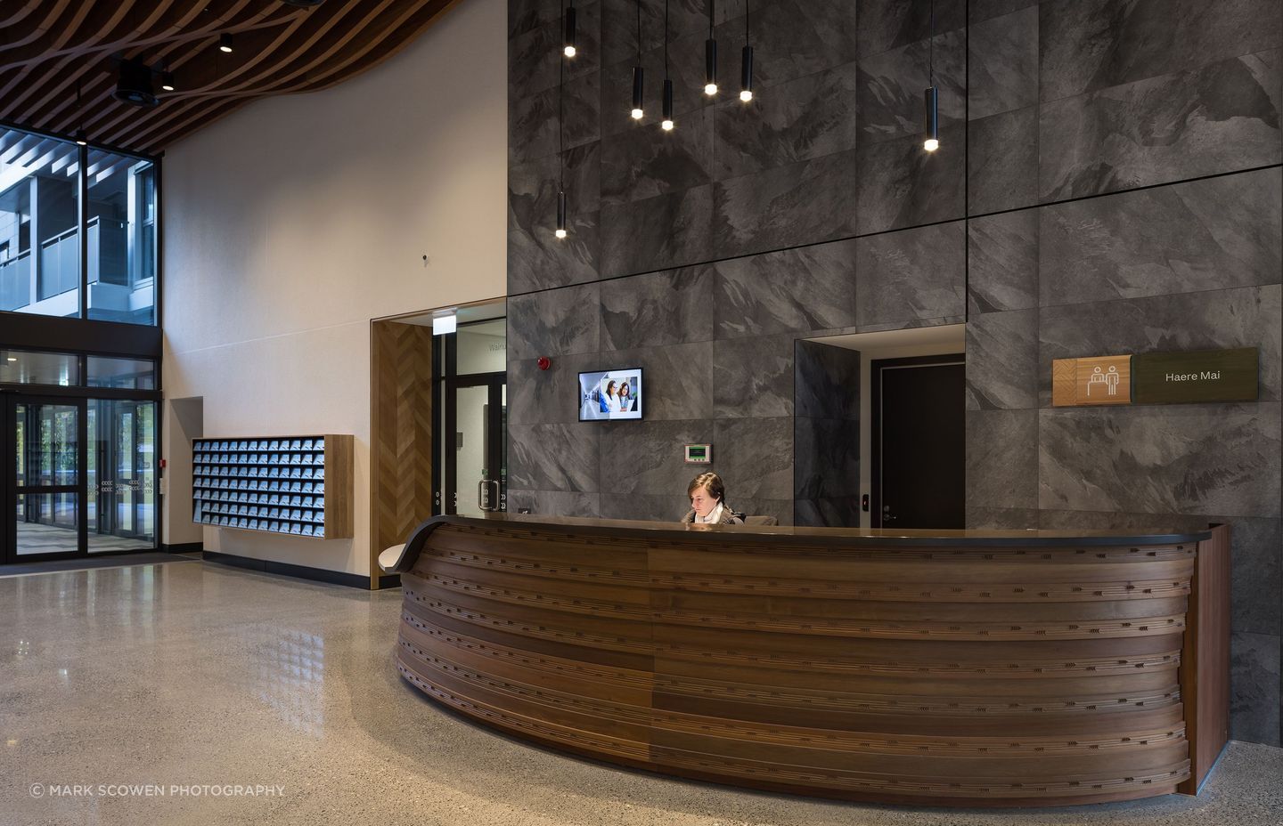 The beautifully carved concierge desk welcomes residents to Te Mātāwai.