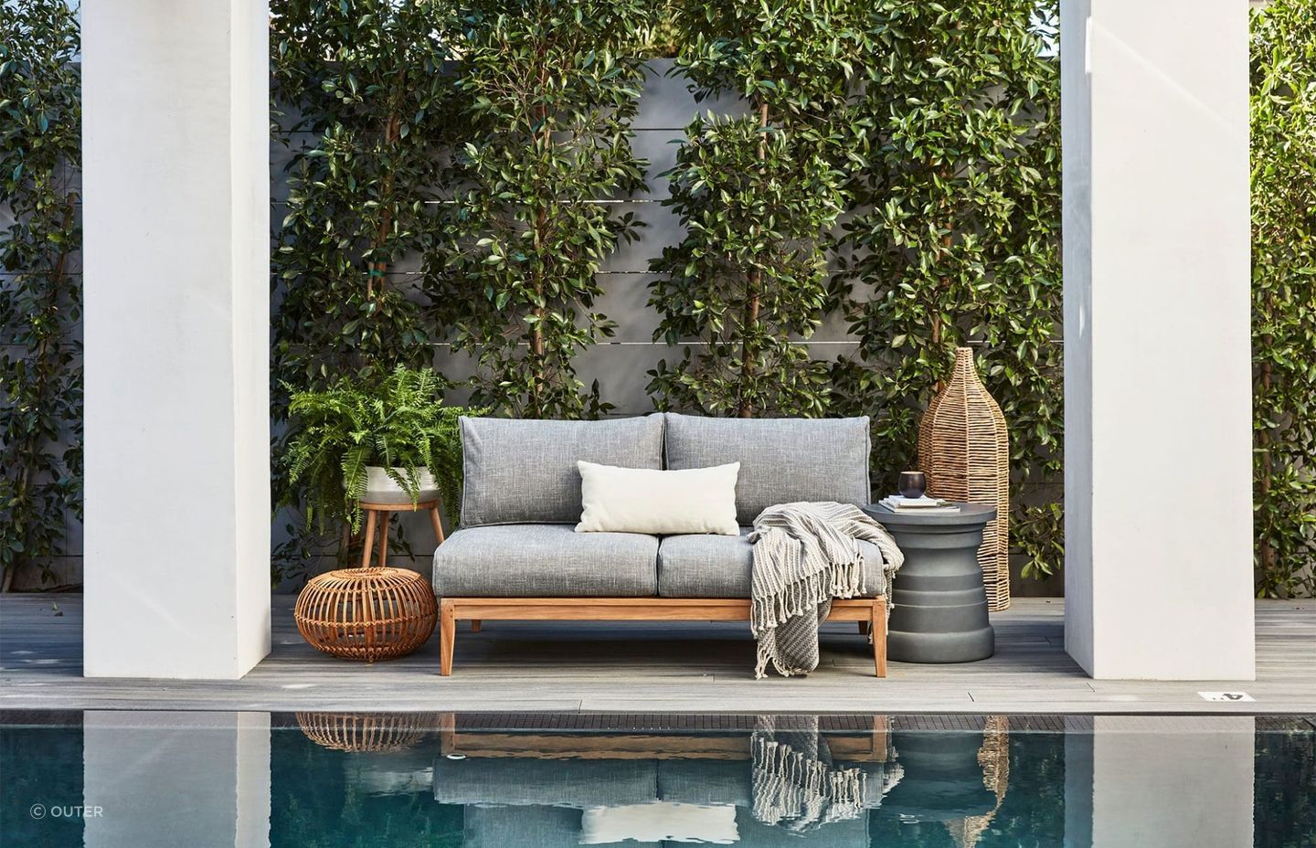 The plush Teak Outdoor Loveseat takes centre stage in a scene that completely embodies comfort