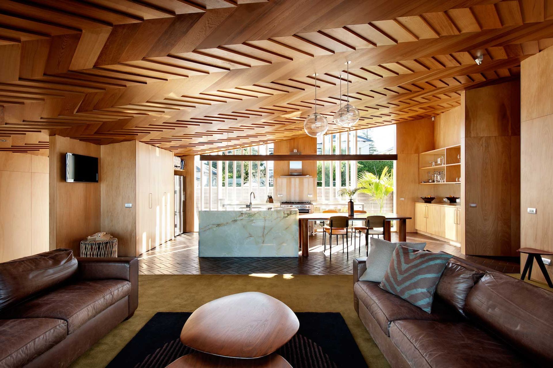 The warm and creative timber furniture and ceiling in the Wood Family Home, Auckland, was constructed by the client and the architect.