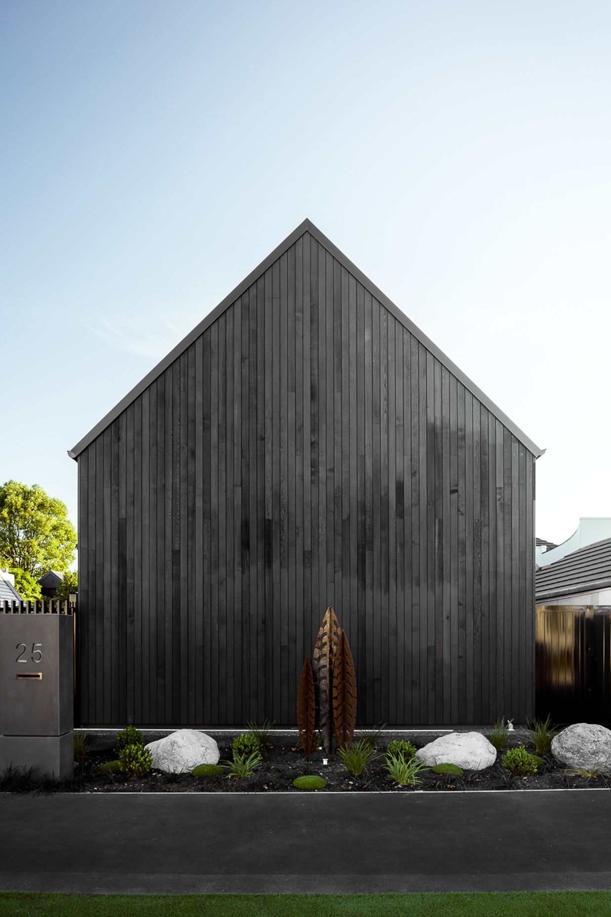 Outerspace used sub-tropical plants to soften this dramatic black cedar-cladding.