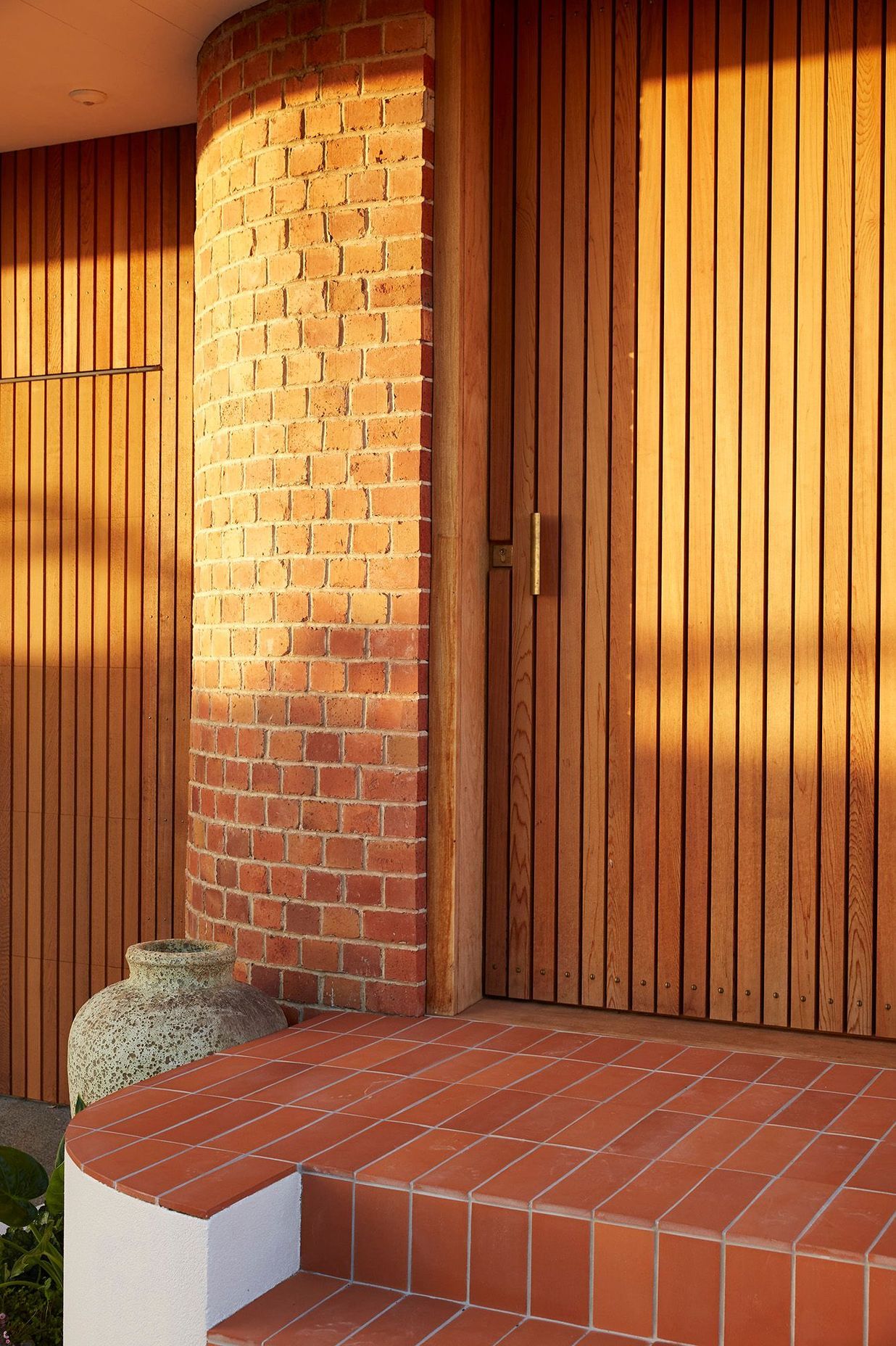 A new entrance punctuates the curved brick of the recently renovated, post-deco Owairaka House, Auckland, by Raukura Turei.
