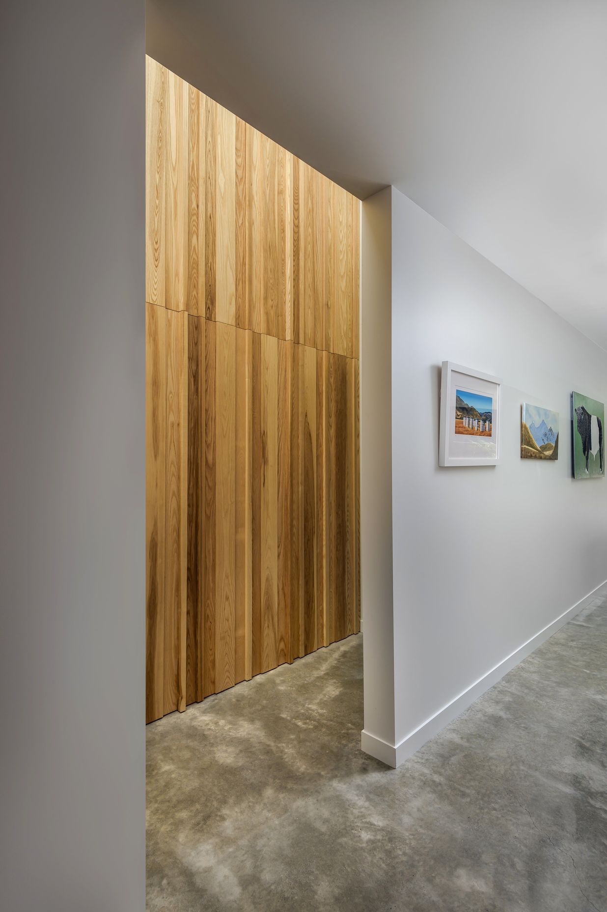 Randomly placed timber boards create a textural feature wall that conceals the entry to the bathroom off the hallway.