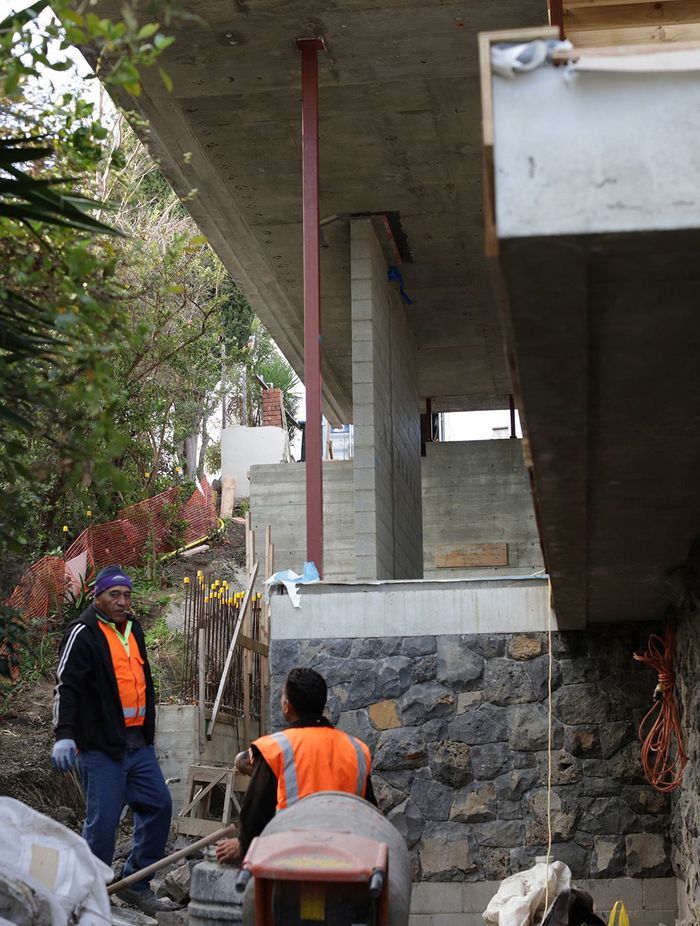 Work being done on the stone wall underneath the second-floor overhang.
