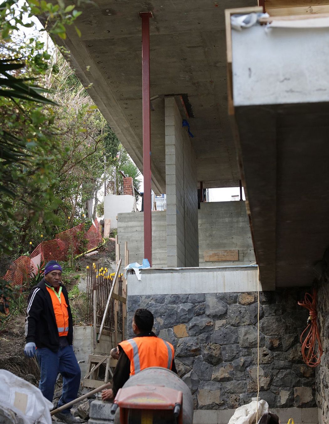 Work being done on the stone wall underneath the second-floor overhang.