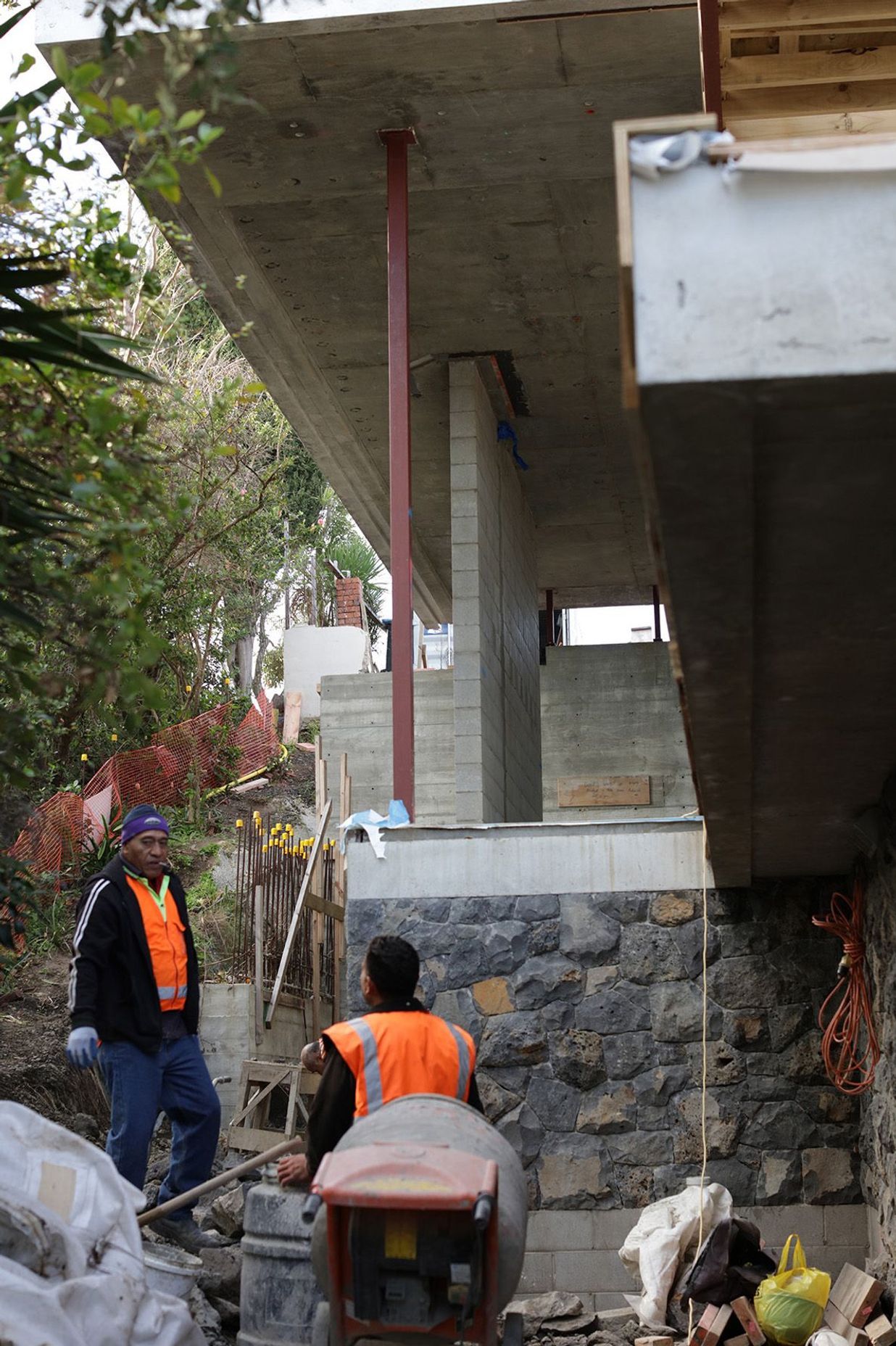 Work being done on the stone wall underneath the second-floor overhang.