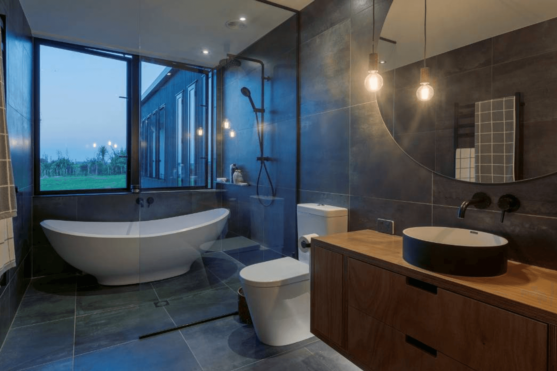 Large tiles that can be used on the walls and continue seamlessly to the floor, in matt black or charcoal grey, make a striking statement.