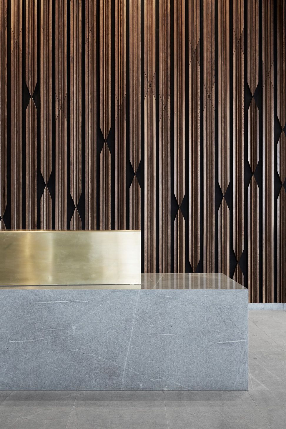 Materials on the ground floor are distilled to stone, timber and brass. 