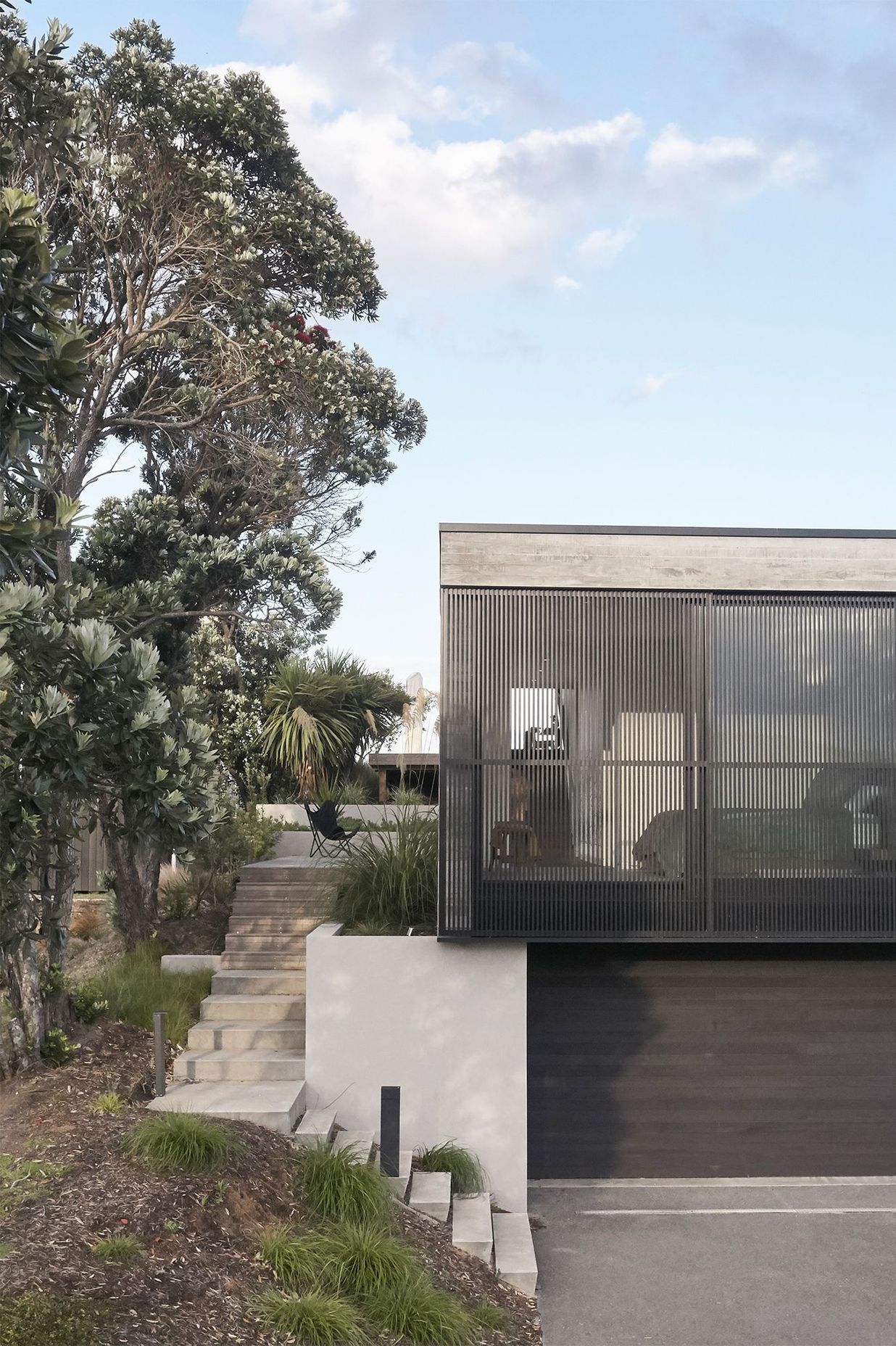 The facade is punctuated by black aluminium screens that provide privacy for the two street-facing bedrooms.