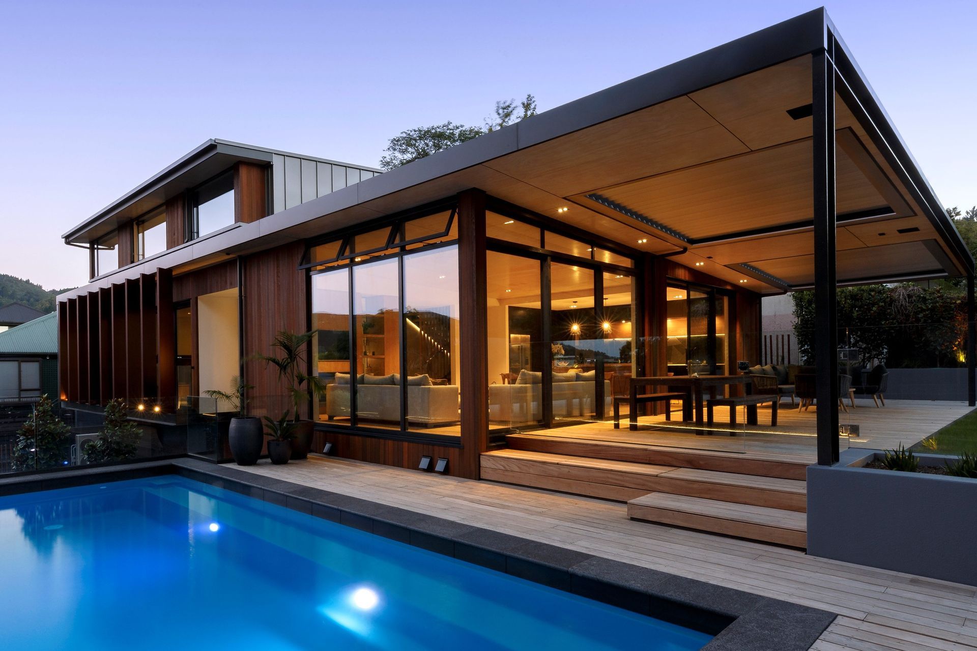 A nightview of the rear of the house with all the lights on.