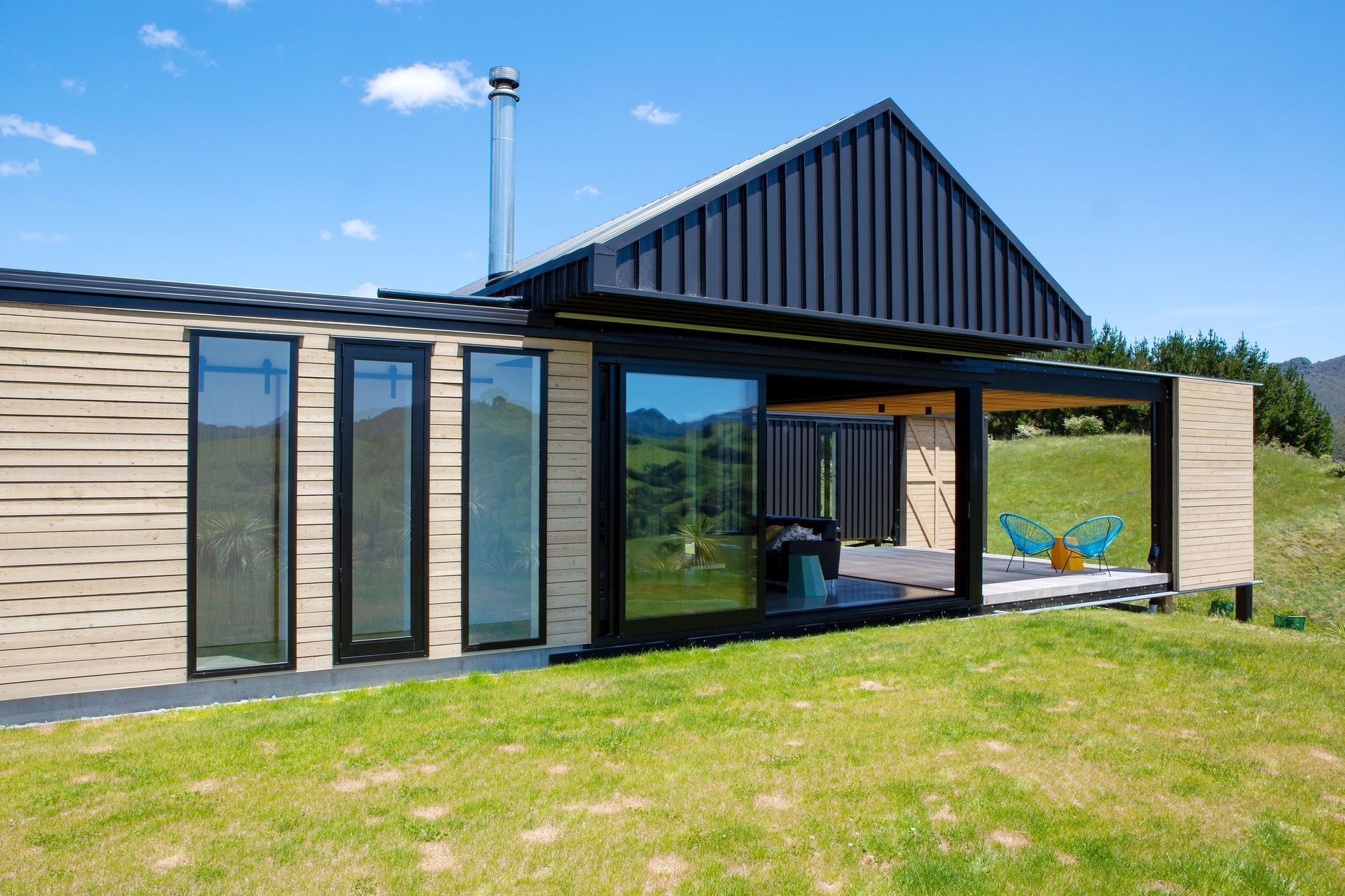 This house is comprised of two rectangular structures, one clad in larch while the other in long run steel.