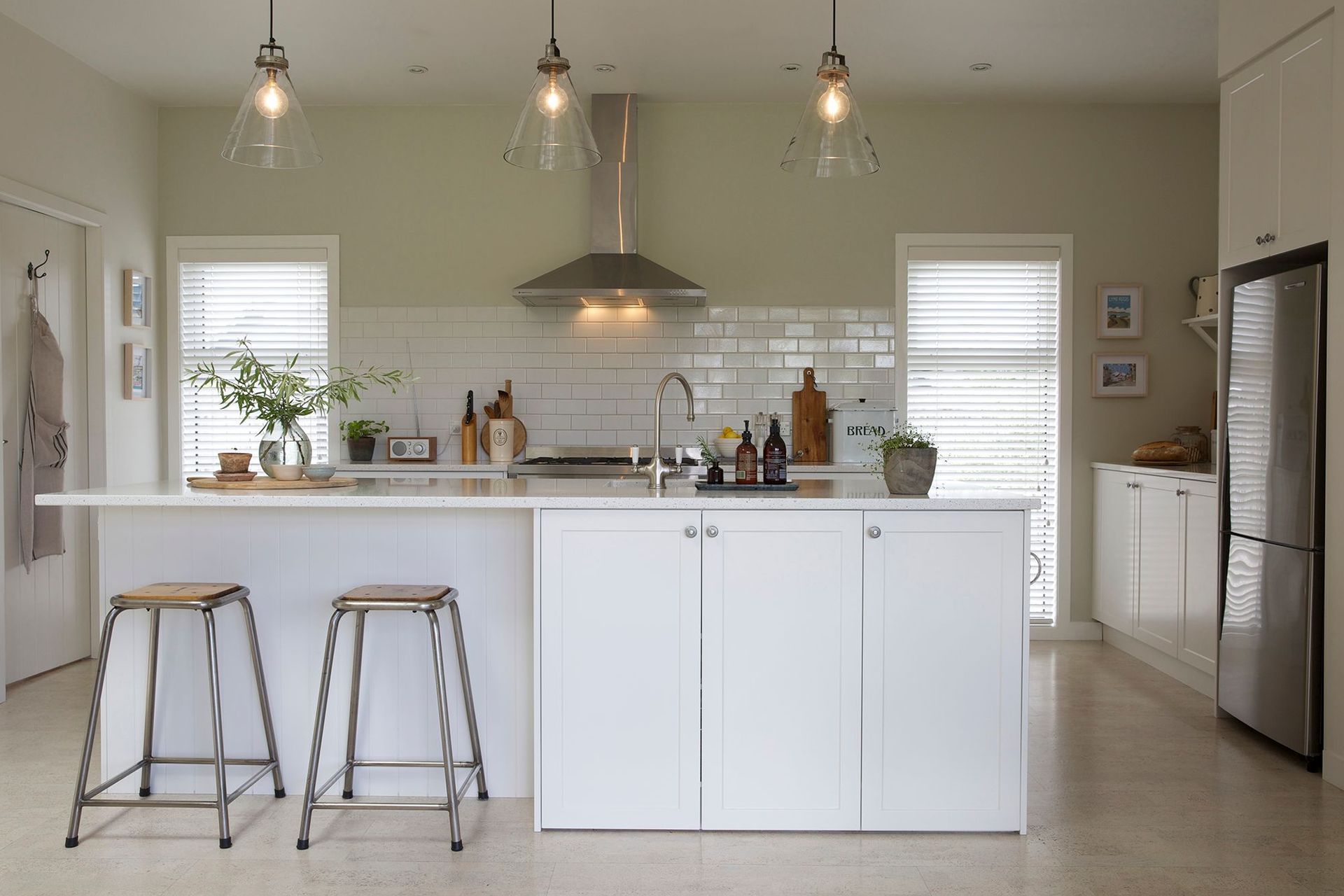 In true farmhouse style, this timeless kitchen is super functional with a large island, laid out for easy access with lots of low cupboards and the laundry situated behind the door on the left.