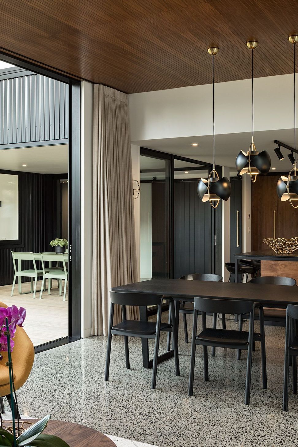 The open-plan kitchen, dining and living spaces flow seamlessly towards the covered courtyard, allowing family life to extend naturally into the landscape.