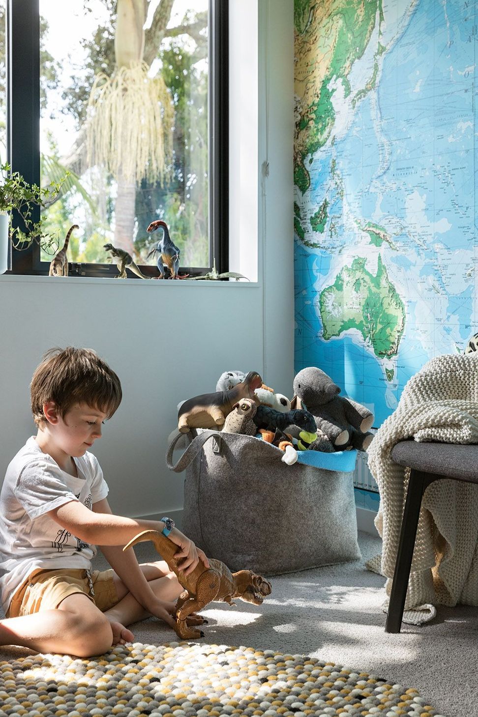 Designed to encourage curiosity and creativity, the children's bedroom features a world map wallpaper, soft carpet and flexible spaces for play and learning.