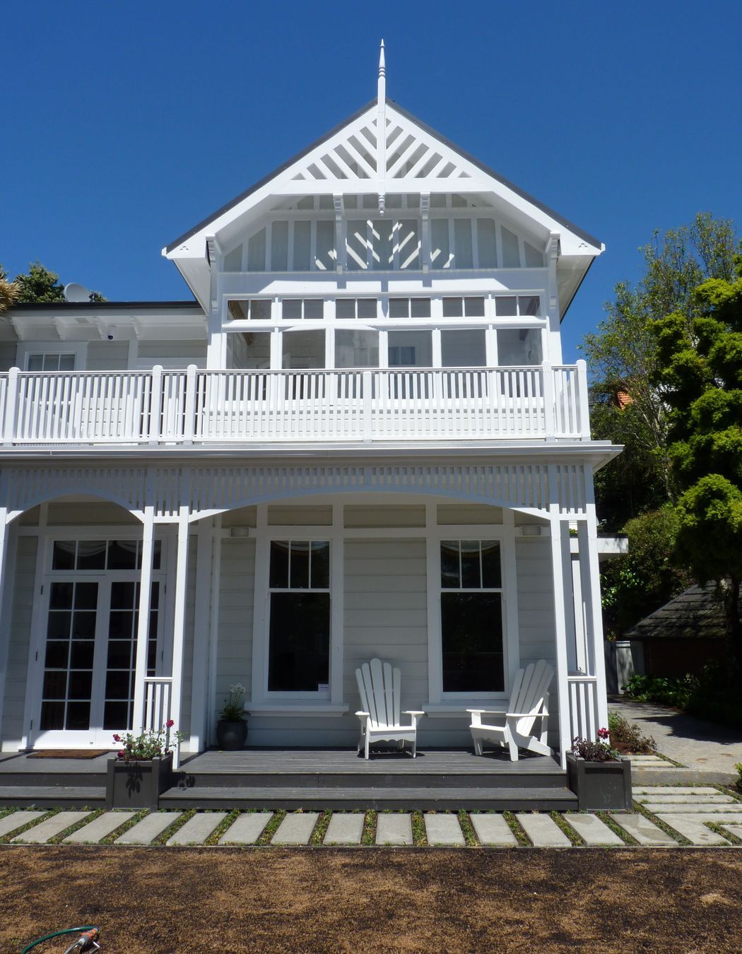 We opened up the verandah to the lawn, installed bottomless built-in Versailles planter boxes &amp; wires for 2 storey tall climbing roses, Cape Cod chairs for gins, and new custom pavers edged in mondo grass, new lawn, Kelburn.