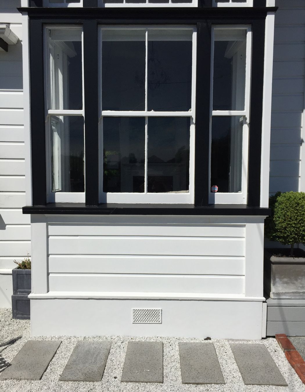 Pavers in white pebbles against black &amp; white detailed villa, Northland.