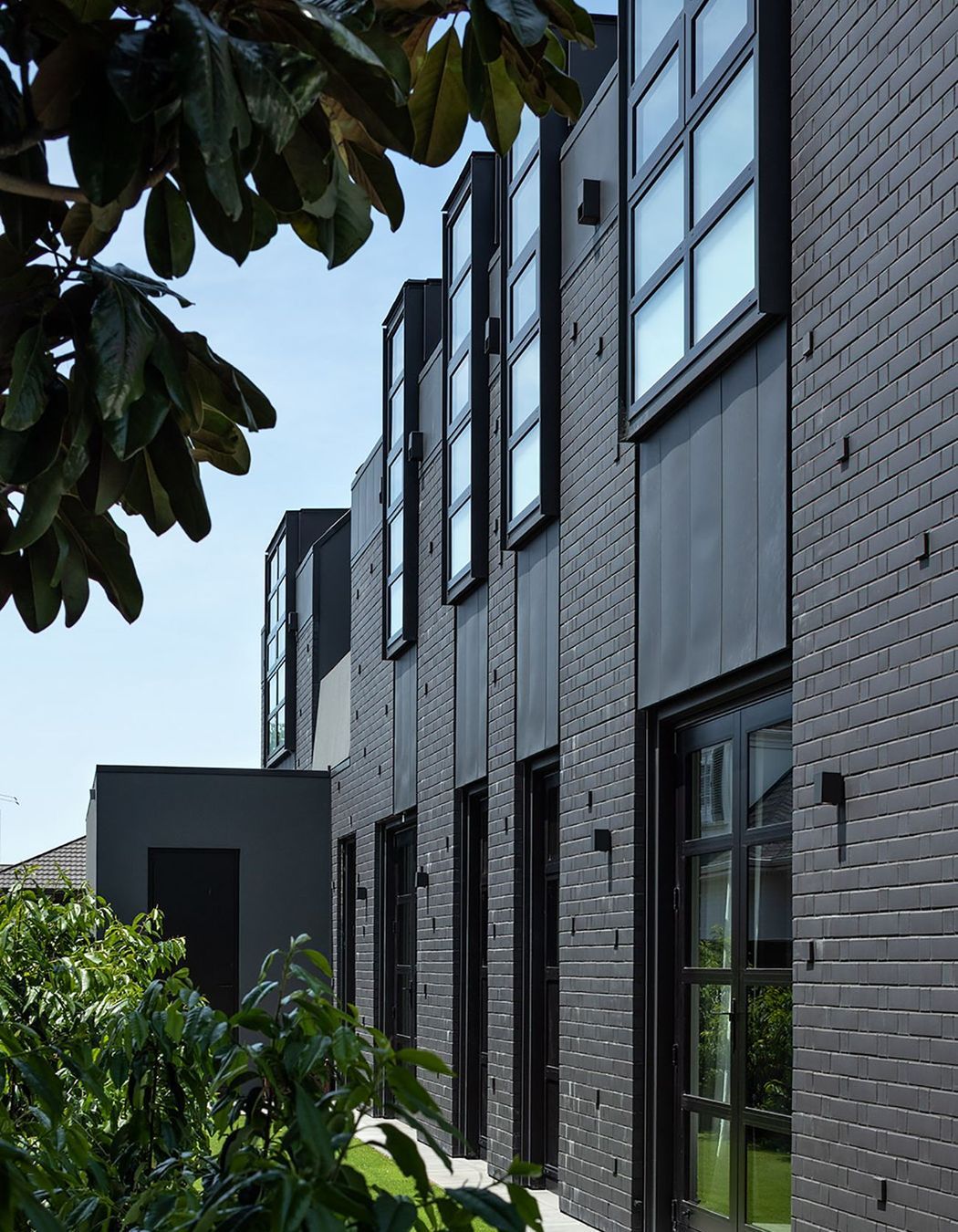 The vast, dark sheathe of materials offer a textural tonality that plays with the intensity, creating an unexpected rhythm.