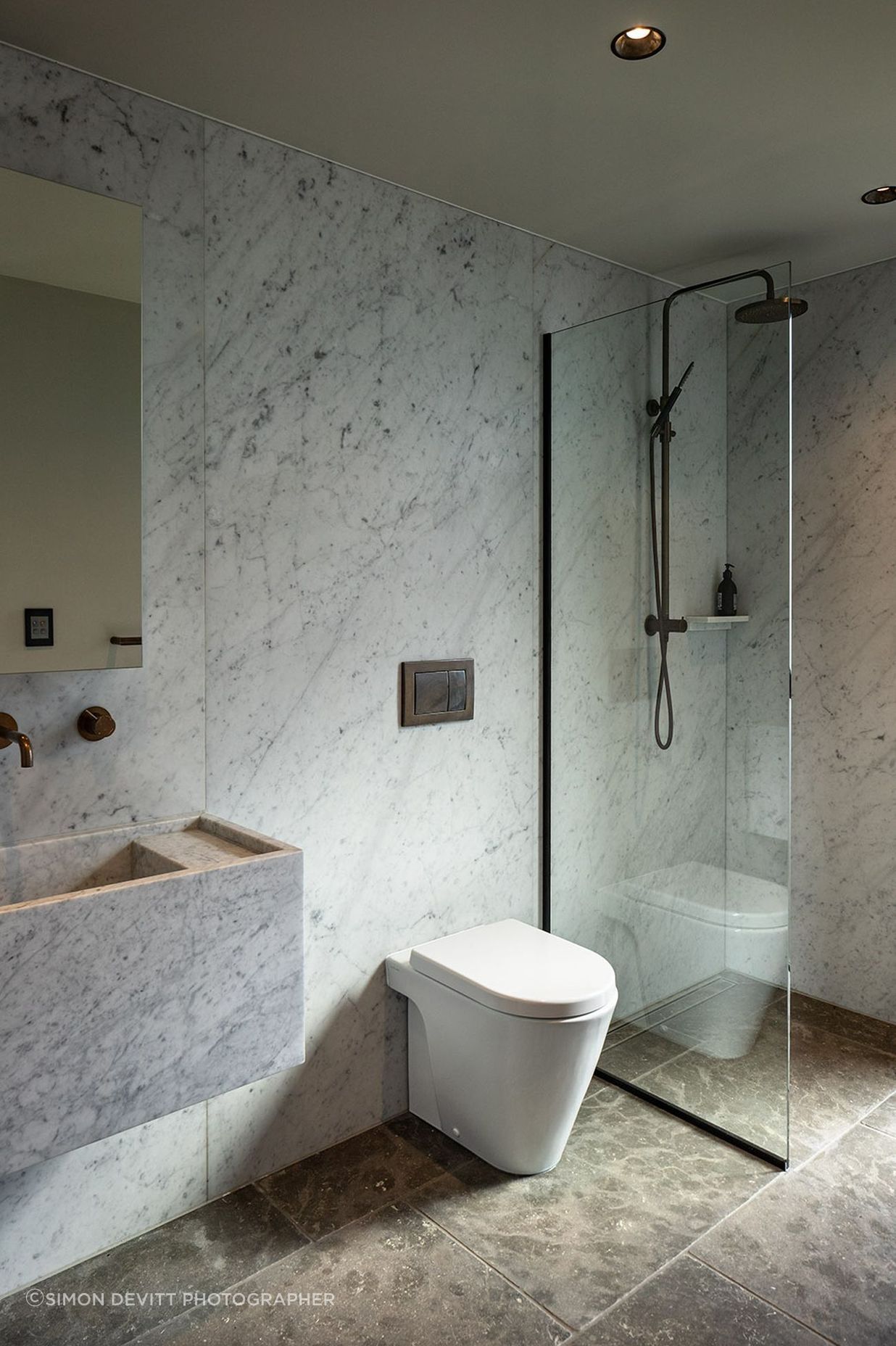 Marble-clad walls and floors combine with sculptured wall-hung basins in the bathrooms.