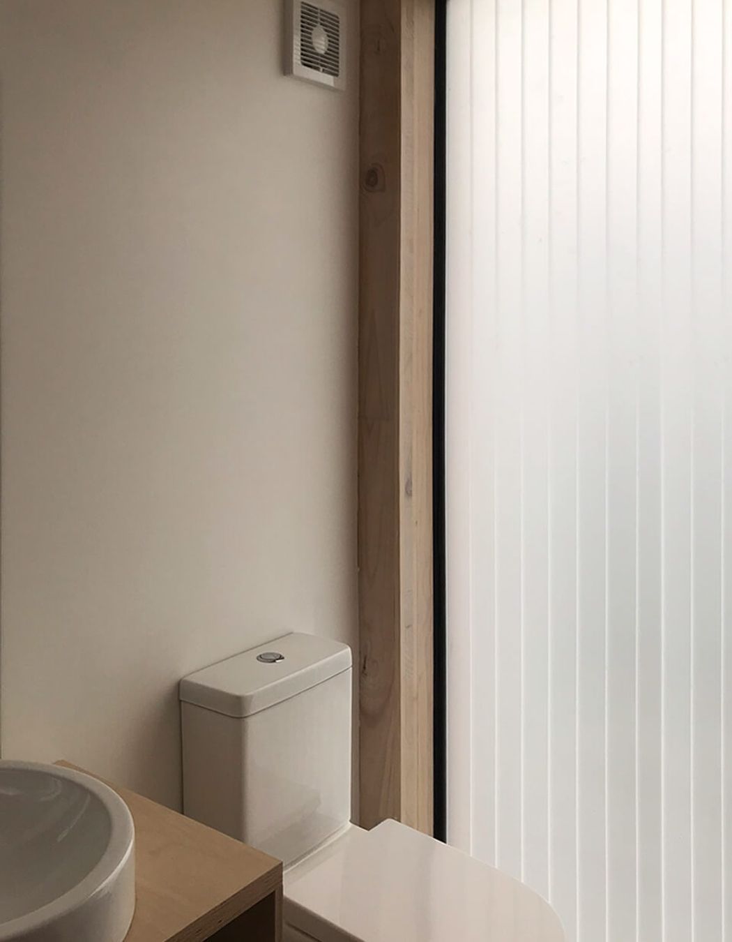 A polycarbonate slot in the wall fills the bathroom with light.
