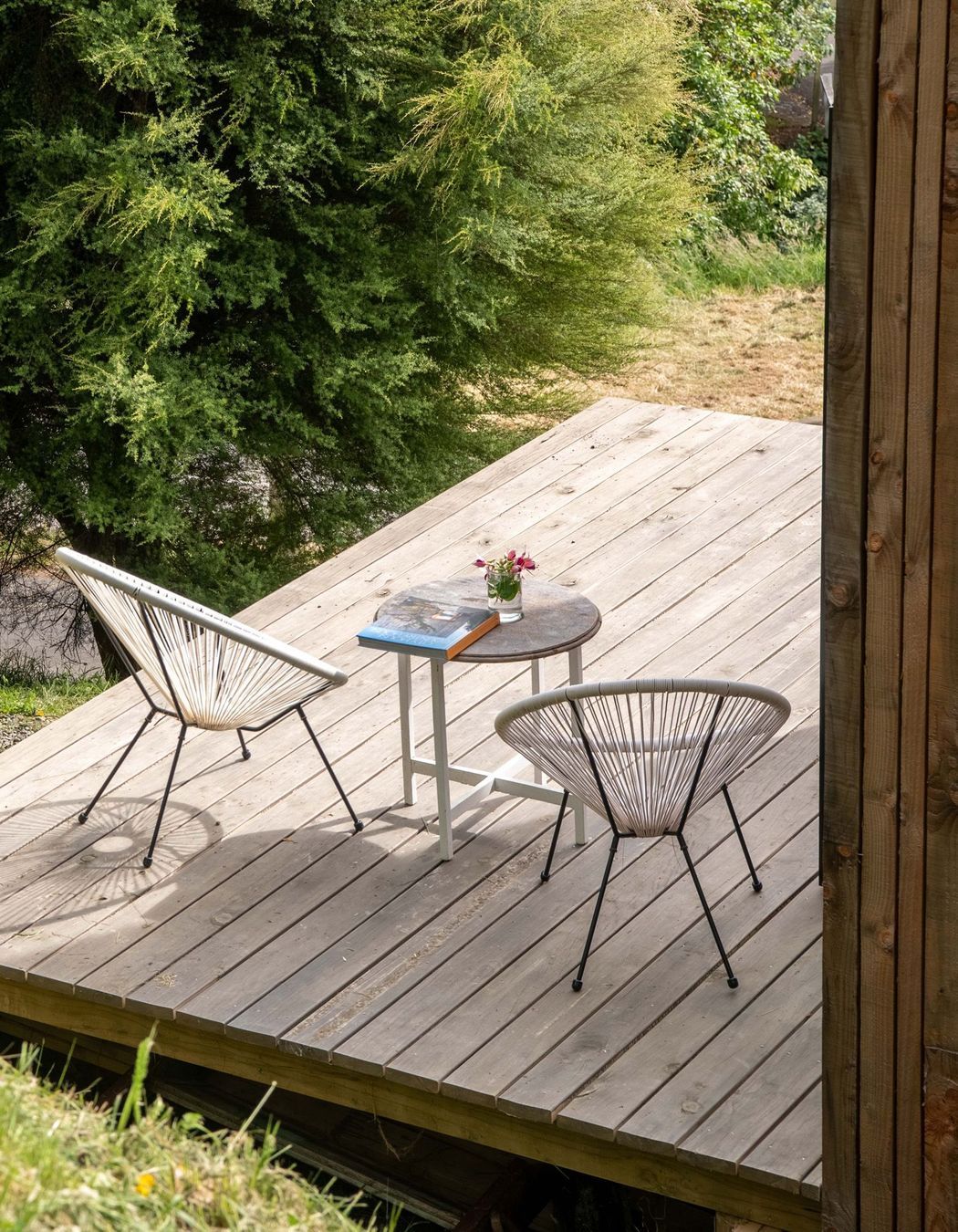 The timber deck with acapulco chairs is the perfect place to relax and listen to the nearby birdsong.