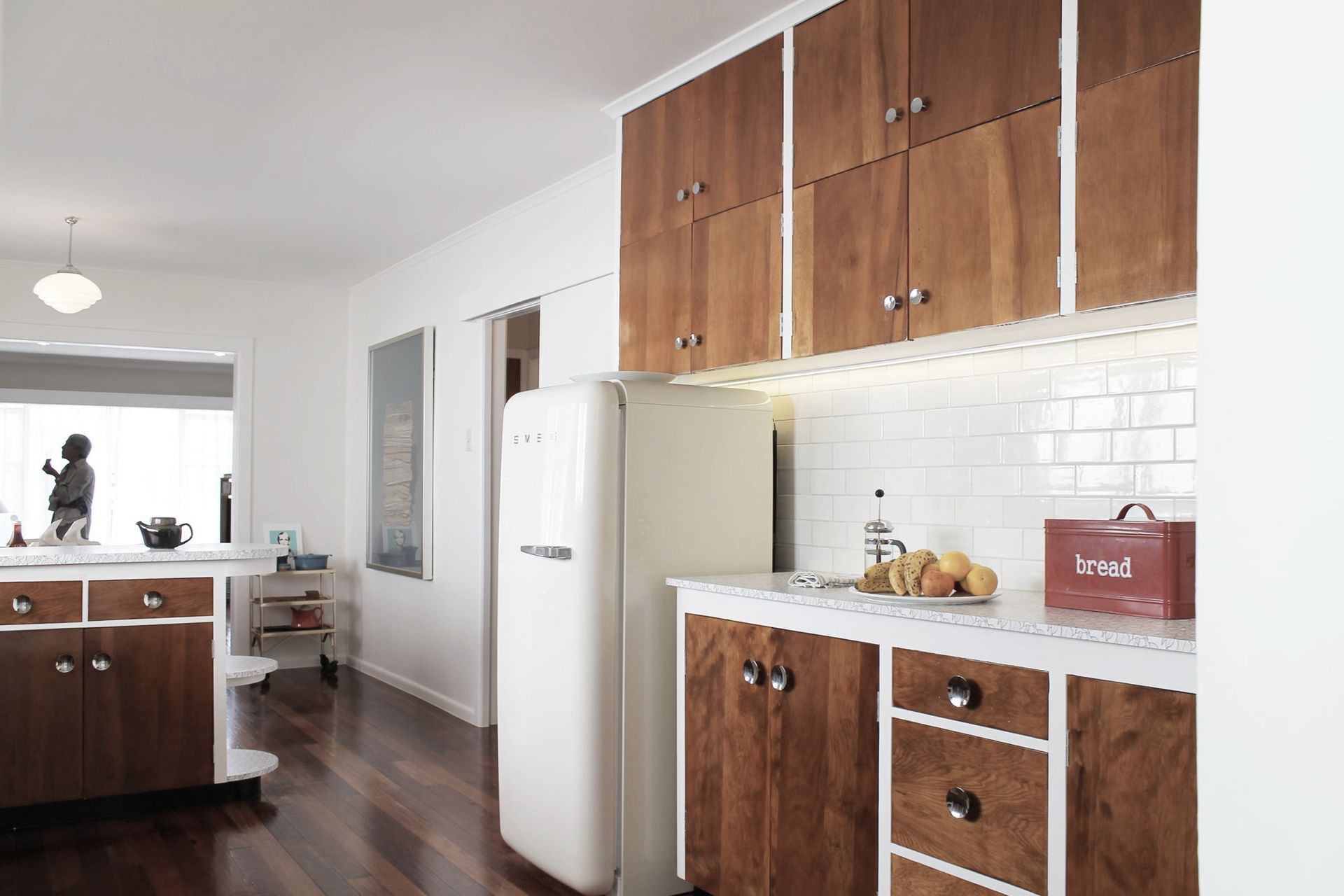 Years of old paintwork were stripped away to reveal a rich grain in the original woodwork. During the day natural light floods the space and highlights this rediscovered timber and the new Formica patterned benchtop. The soft tones of the walls and tiles 