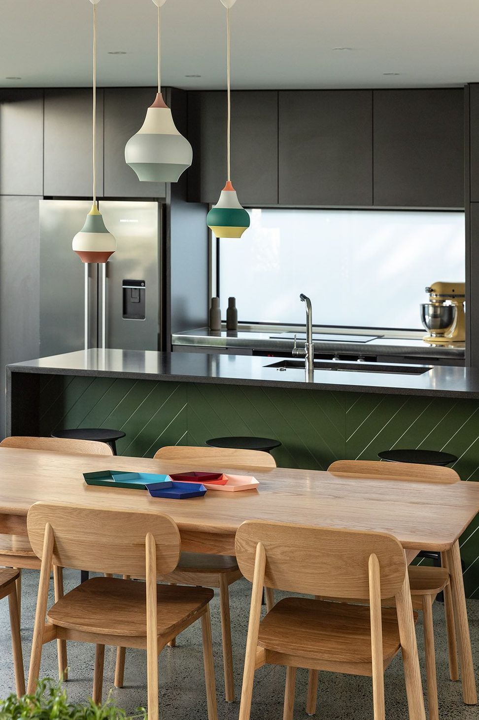 This intimate view captures the balance of colour, texture and natural light within the kitchen and dining spaces. The carefully curated finishes create a warm yet understated family interior.