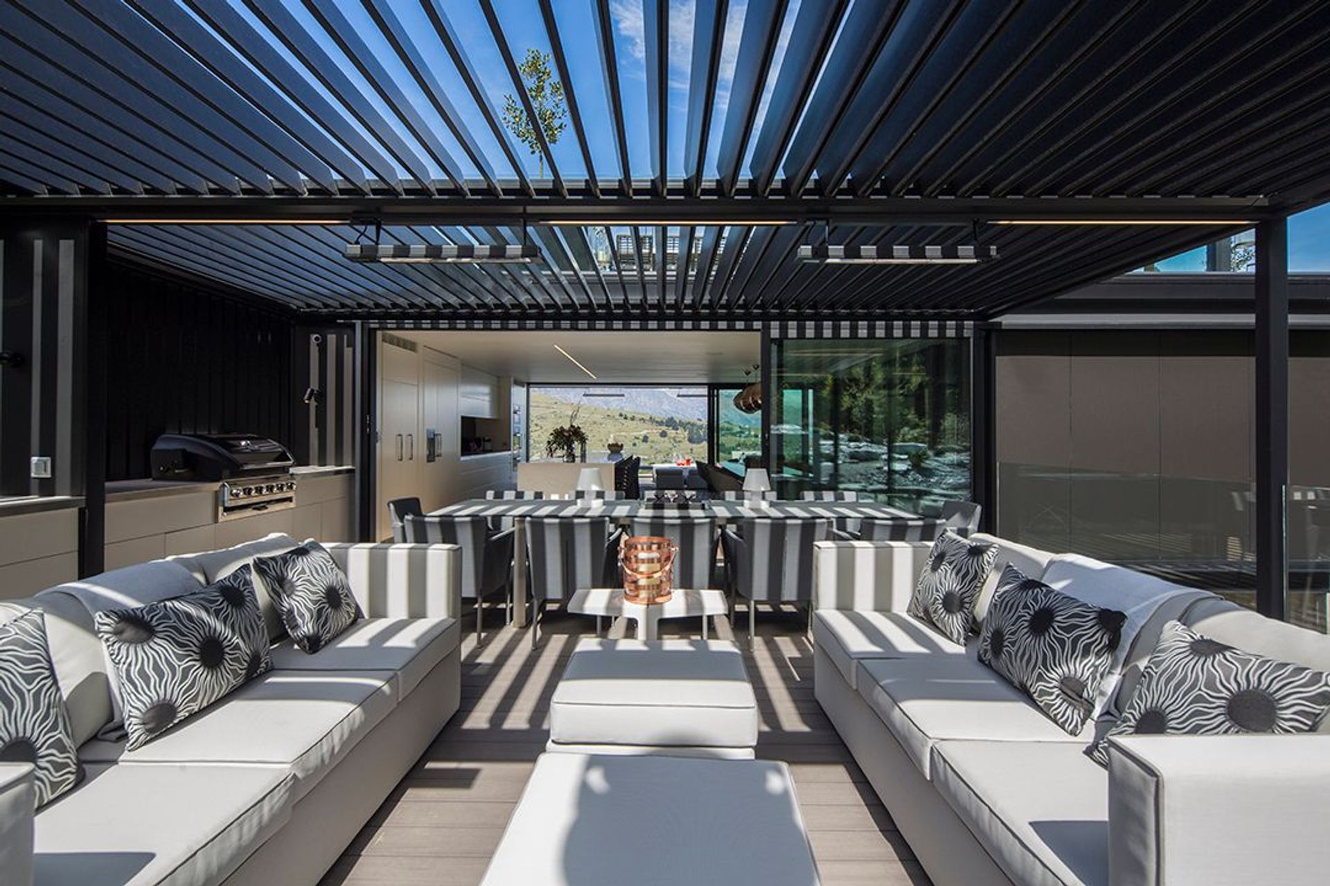 The outdoor lounge area and kitchen is covered with adjustable louvres for shading. Stacker sliding doors allow a view shaft through the interior to the landscape on the opposite side.