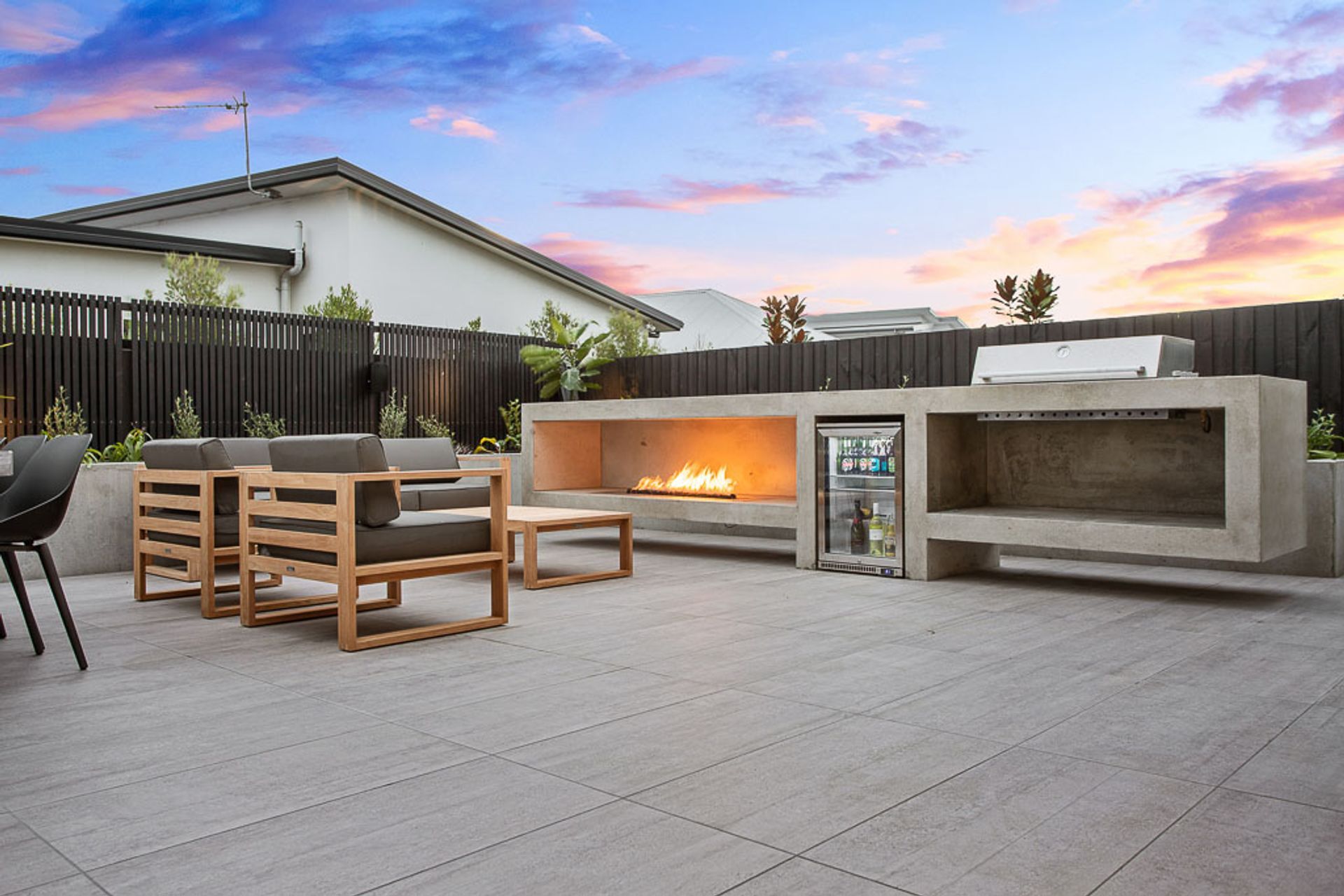The backyard barbeque space with built-in fridge and gas fire.