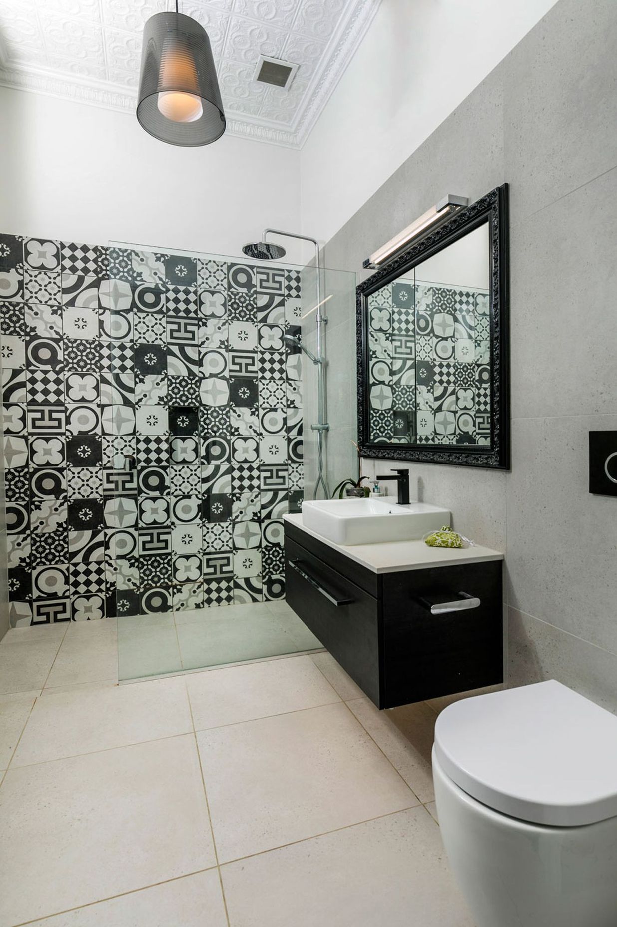 Bold patterns tiles created a feature in the bathrooms, and the mirror was designed with a picture frame around it to create a difference to the ordinary recessed mirror cabinet.
