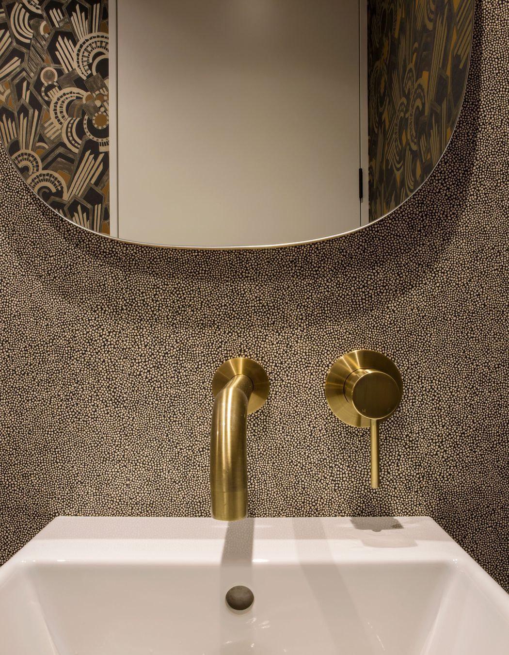 Brass tapware and retro wall coverings add personality to the powder room.