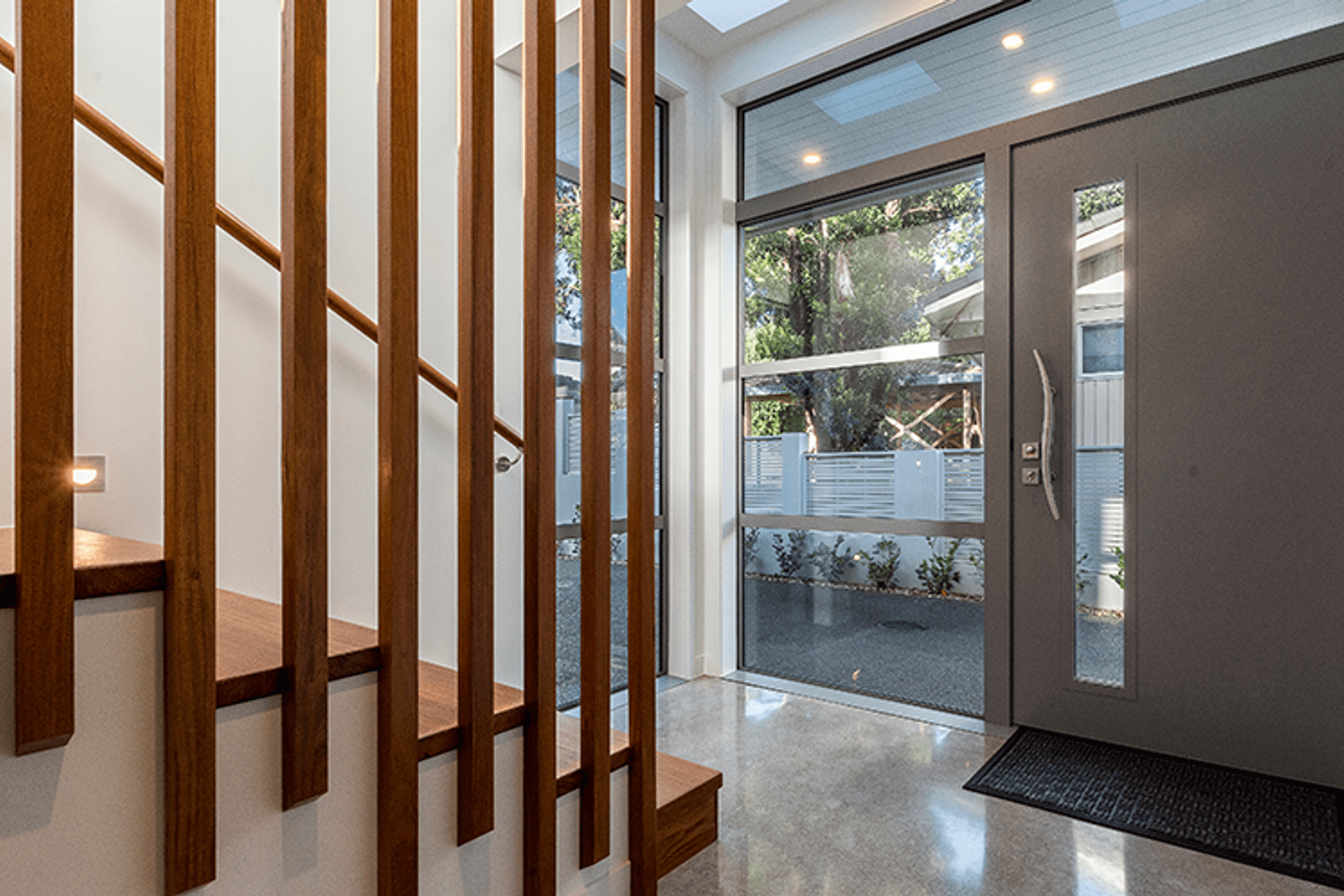 The entry features a hardwood staircase and cloakroom and polished concrete floors throughout. 