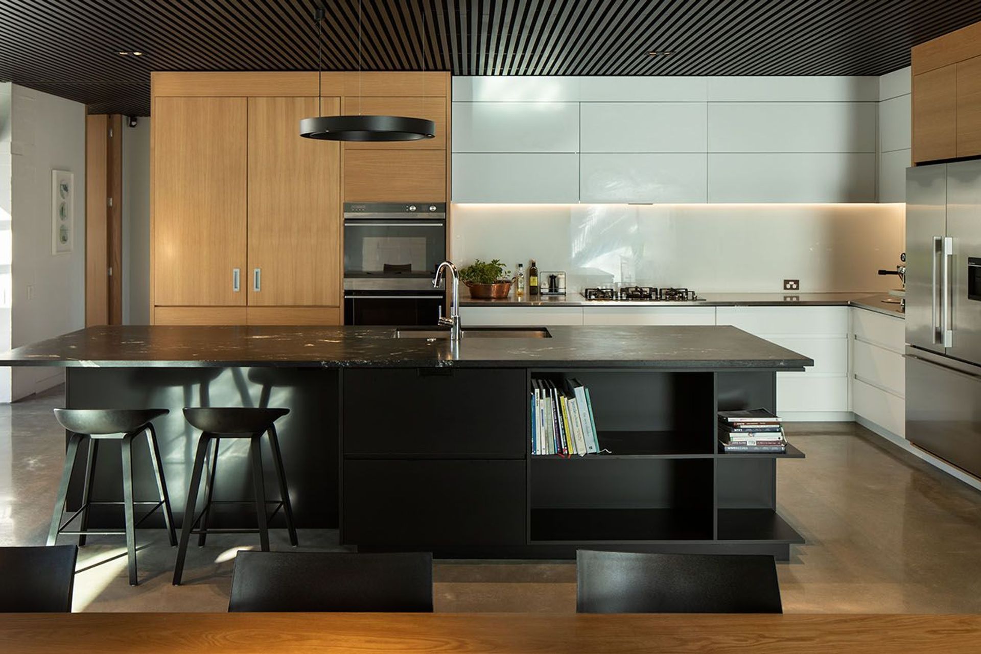 A central aspect of the interior scheme - the acoustic ceddar batten ceiling - continues seamlessly from the open plan living, kitchen and dining area into the covered outdoor courtyard.