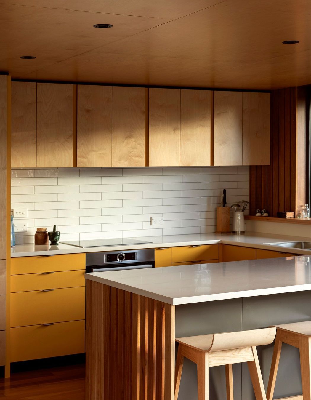 Birch ply cabinetry is used in the kitchen with accents of yellow laminate and Australian hardwood flooring.